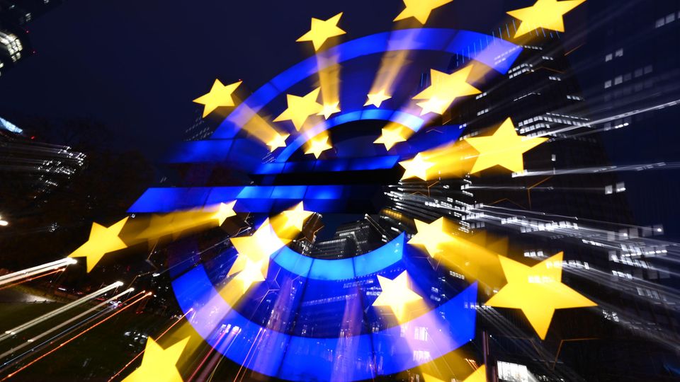 Die Euro-Skulptur des Künstlers Ottmar Hörl leuchtet am Abend vor den Bankentürmen