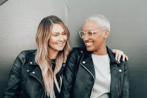 Zwei Frauen liegen sich lachend in den Armen.