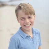 Prinz George lacht am Strand in die Kamera
