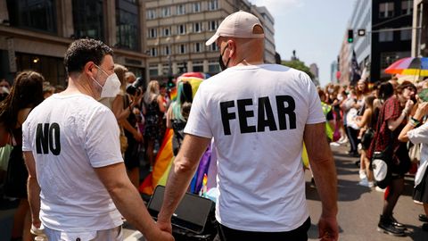Zwei Männer halten sich auf der CSD-Parade 2021 in Berlin an den Händen, auf ihren T-Shirts steht "No fear"