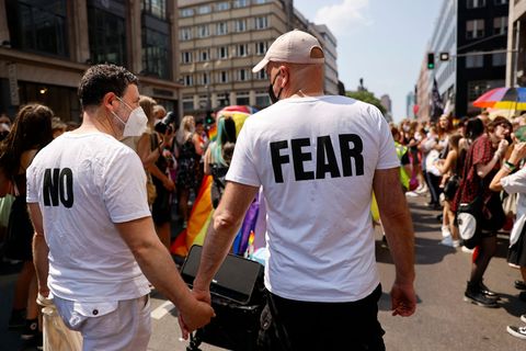 Zwei Männer halten sich auf der CSD-Parade 2021 in Berlin an den Händen, auf ihren T-Shirts steht "No fear"