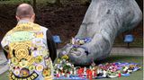 Blumen und Kerzen an der Bronzestatue von Uwe Seelers Fuß