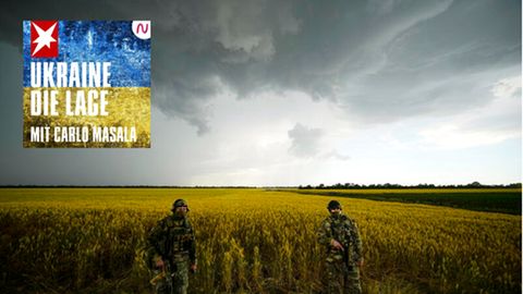 Russische Soldaten bewachen ein Gebiet neben einem Weizenfeld