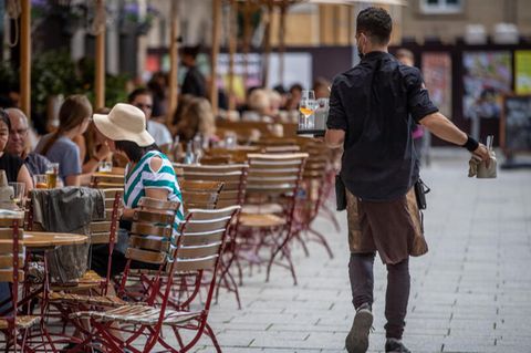 Ein Kellner bedient auf der Terrasse eines Restaurants