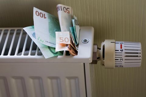 Flächenspeicherheizung: Geldscheine stecken in einer FHeizung.