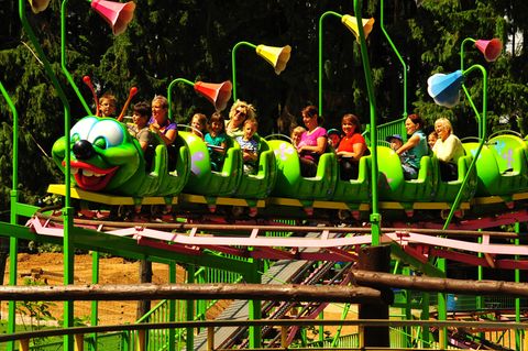 Familien fahren mit der Kinderachterbahn im Freizeitpark Plohn