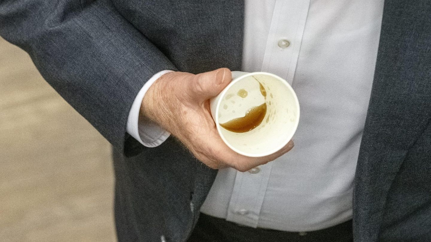 Älterer Mann hält leeren Kafeebecher in der Hand