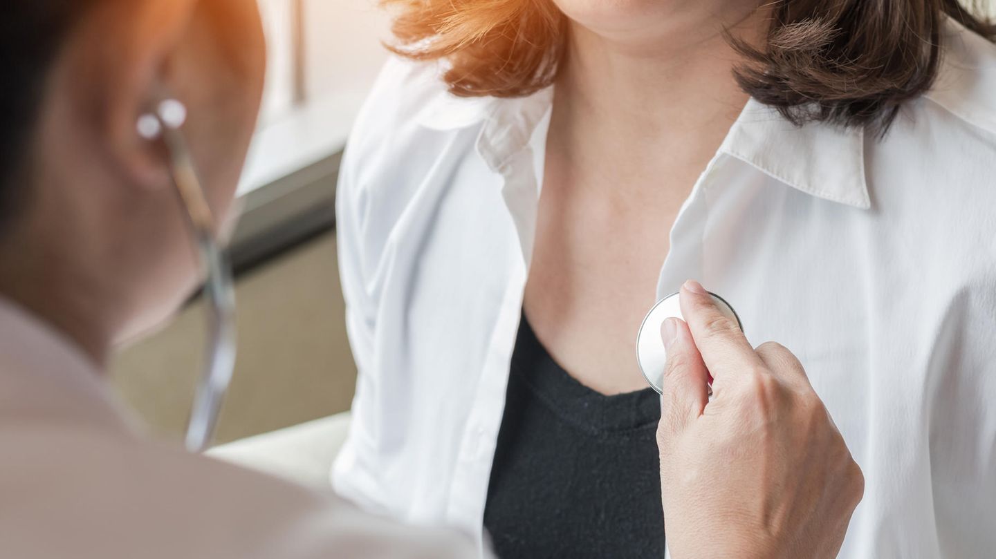 Eine Ärztin hört eine Patientin mit dem Stethoskop ab