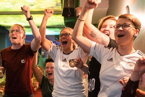 Fußballfans verfolgen die Partie in einer Kneipe und bejubeln den Treffer der deutschen Mannschaft