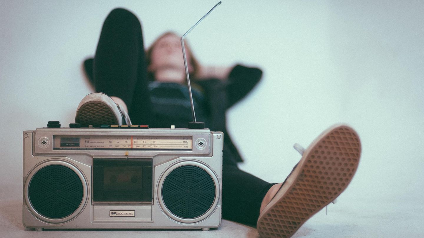 Ein Mann sitzt entspannt hinter einem Radio.