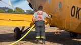 Mann betankt kleines gelbes Flugzeug