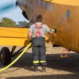 Mann betankt kleines gelbes Flugzeug