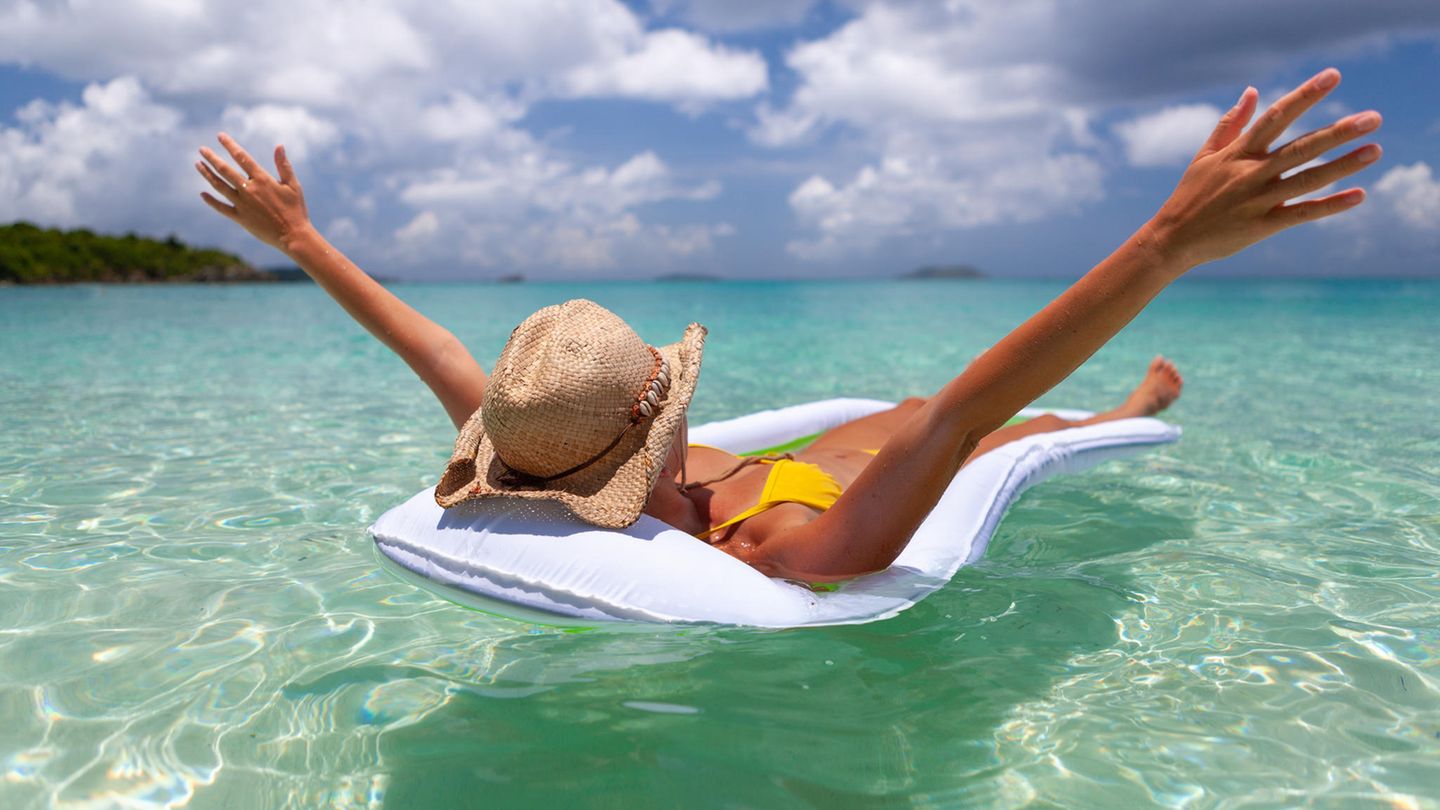 Eine Frau schwimmt auf einer Wasserhängematte