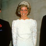 Die Queen Mary's Lover's Knot Tiara  Die Geschichte der Queen Mary's Lover's Knot begann bereits im Jahr 1818. Da bekam sie Prinzessin Auguste von Hessen geschenkt. Sie vererbte das Stück ihrer Tochter und so ist die Tiara heute noch im Besitz des Hauses Mecklenburg-Strelitz. 1913 gab Augustes Enkelin, Queen Mary, eine sehr ähnliche Tiara beim Hof-Juwelier Garrard in Auftrag. Zwischen den beiden Diademen gibt es mehrere Unterschiede. Angefangen beim Namen: Das deutsche Exemplar heißt Cambridge Lover's Knot Tiara, nach dem Titel, den Auguste im Zuge ihrer Hochzeit mit dem Herzog von Cambridge erhält. Währenddessen ist die Replik nach Queen Mary benannt. Außerdem verfügt die ältere Version über große Perlen über den Bögen, während bei der jüngeren große Diamanten angebracht sind. Queen Mary vererbte die Tiara ihrer Enkelin, der späteren Queen Elizabeth II. In ihrem Besitz ist das prunkvolle Stück bis zu ihrem Tod 2022. Jetzt gehört sie König Charles III. Zu denjenigen, die sich das Schmuckstück leihen durften, gehörte zum Beispiel Prinzessin Diana. Auf dem Foto trägt sie die Queen Mary's Lover's Knot Tiara im Jahr 1985 beim Staatsbesuch in den USA.