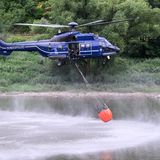 Blauer Hubschrauber mit Wassersack