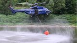 Blauer Hubschrauber mit Wassersack