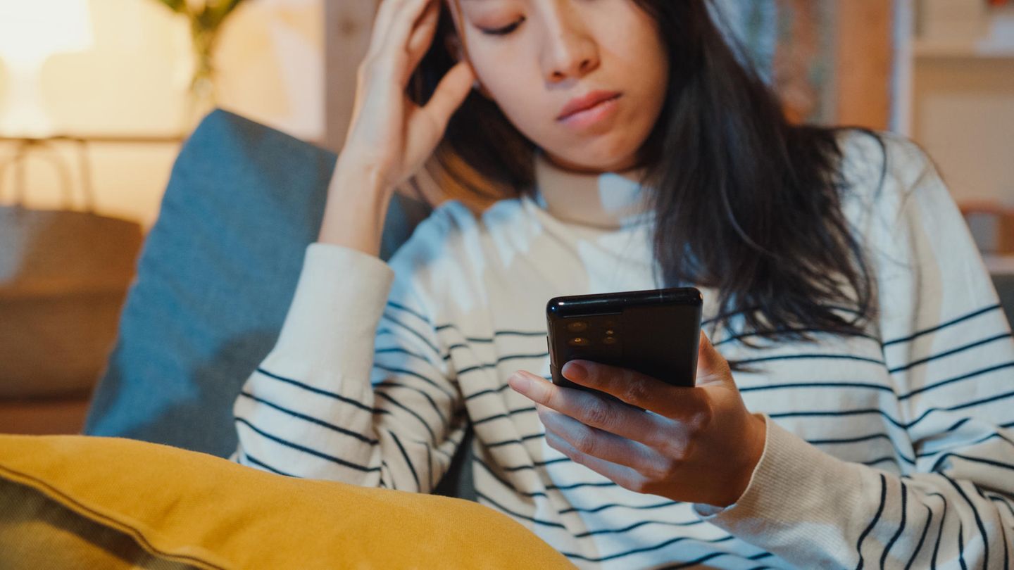 Frau schaut auf ihr Handy und nutzt Social Media