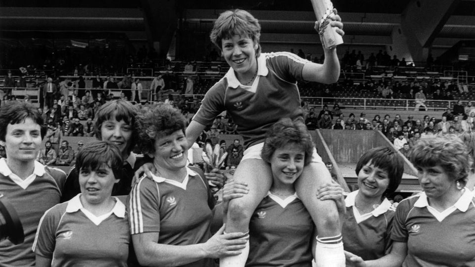 Fußballerinnen stehen glücklich vor einer Tribüne