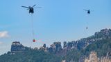 Hier fliegen Hubschrauber der Bundeswehr mit Löschwasser-Außenlastbehältern, um die Waldbrände im Nationalpark Sächsische Schweiz zu löschen.