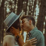 Ein Paar küsst sich im Wald.