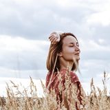 Eine Frau lächelt auf einem Feld zufrieden.