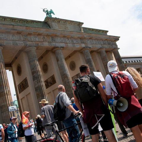 Teilnehmer der Demonstration "Uneingeschränkte Wiederherstellung sämtlicher Grundrechte" stehen am Brandenburger Tor