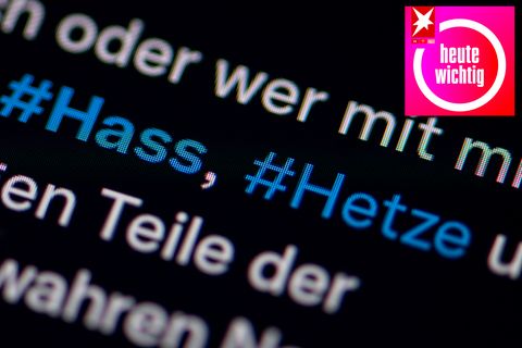 Auf dem Bildschirm eines Smartphones sieht man die Hashtags Hass und Hetze in einem Twitter-Post