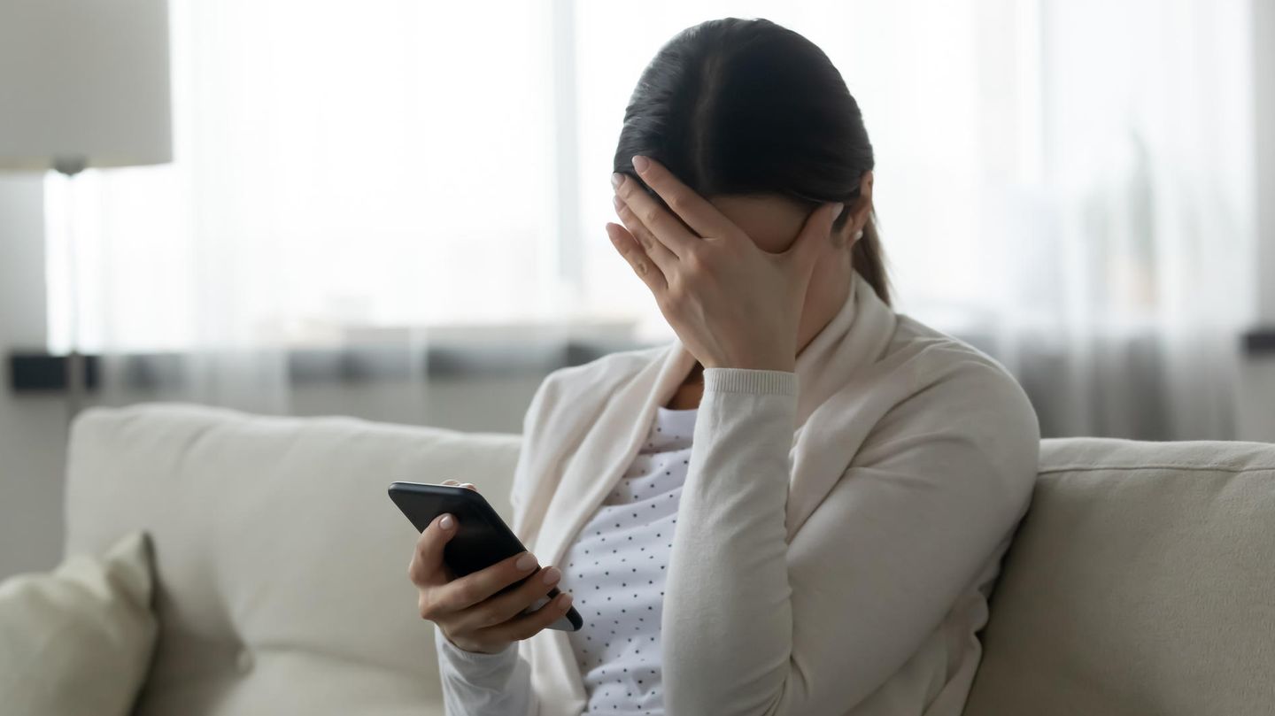 Eine junge Frau hält sich die Hand vor die Stirn