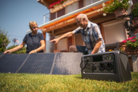 Zwei Personen bauen Solarpenals für einen Solargenerator auf.
