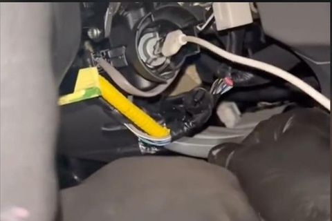 Ein USB-Kabel steckt in der Zündung eines Fahrzeugs der Marke Kia