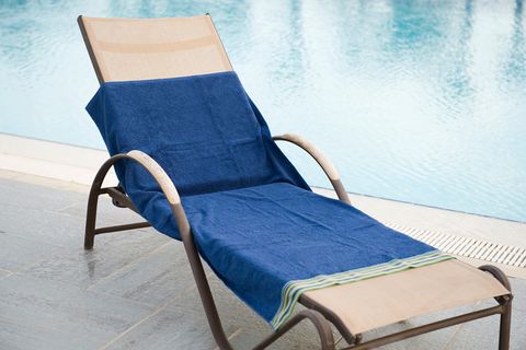 Eine Liege mit einem Handtuch an einem Pool