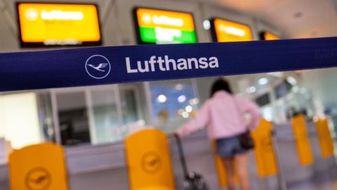 Eine Passagierin wartet an einem Lufthansa Service-Schalter am Flughafen München vorbei