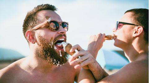 Zwei Männer essen Eis in der Sonne