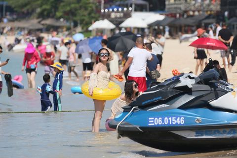 Touristen am Strand von Sanya