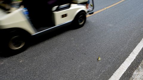 Ein Golfcart fährt auf einer Straße