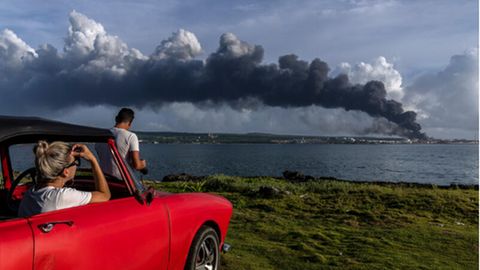 Menschen auf Kuba beobachten, wie eine riesige Rauchwolke vom Supertankerstützpunkt aufsteigt