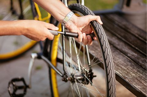 Mini-Fahrradpumpen im Vergleich: Mann pumpt Hinterrad mit Minipumpe auf