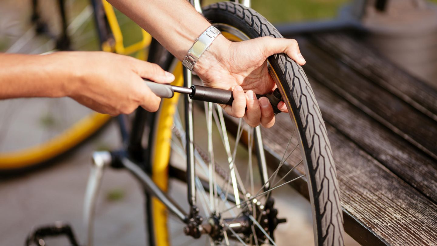 Mini-Fahrradpumpen im Vergleich: Mann pumpt das Hinterrad mit einer Mini-Pumpe auf