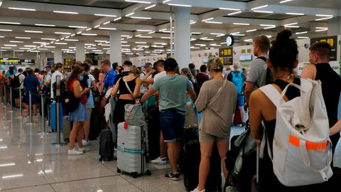 Reisende warten am Flughafen von Mallorca auf die Gepäckaufgabe.
