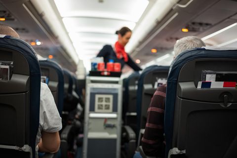 Stewardess bedient in Flugzeug die Passagiere
