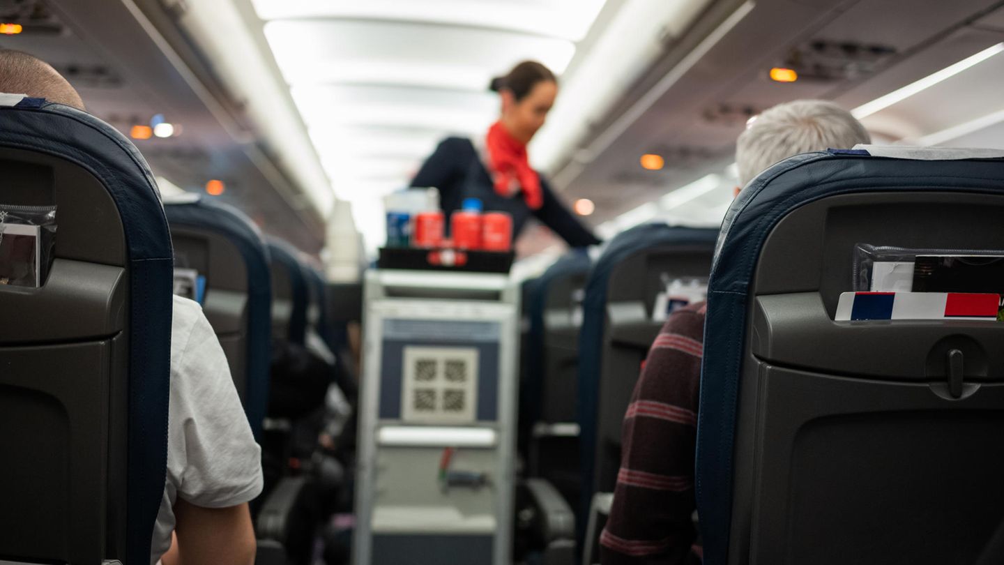 Stewardess bedient in Flugzeug die Passagiere