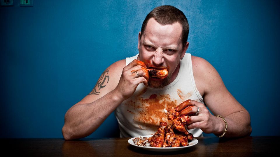 Ein Mann isst einen Haufen Fleisch
