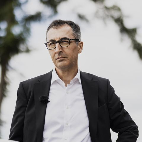Cem Özdemir mit NABU-Flagge im Hintergrund