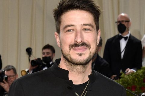Marcus Mumford steht in New York auf dem roten Teppich und lächelt in die Kamera