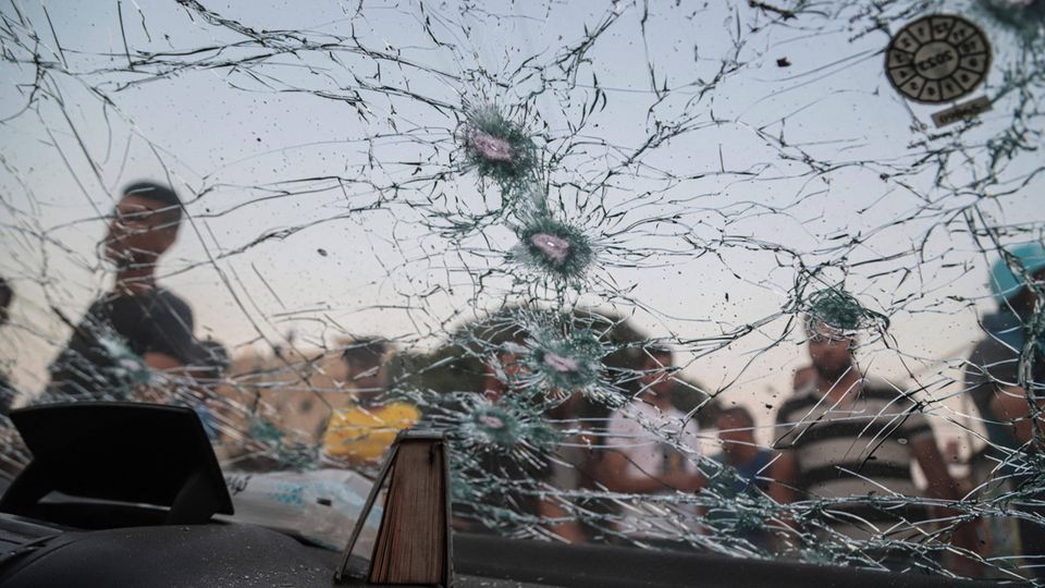 Palästinenser inspizieren die Scheibe eines durch die israelischen Luftangriffe beschädigten Autos in Gaza