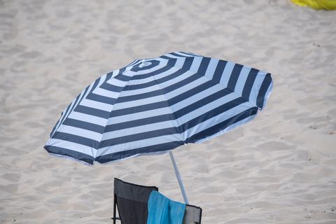 Ein Sonnenschirm steht bei sonnigem Wetter am Strand