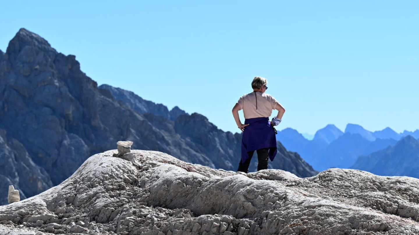Eine Wanderin genießt auf dem Zugspitzplatt die Fernsicht