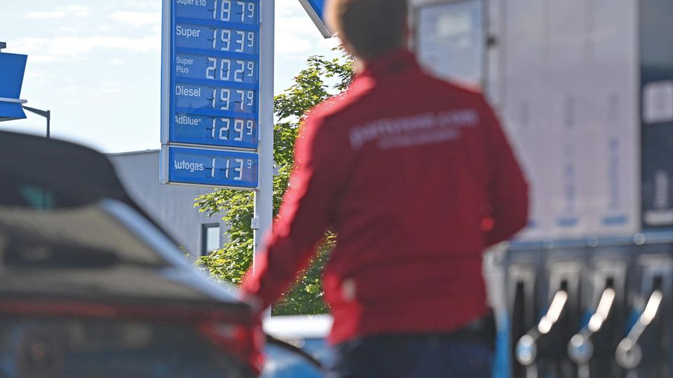 Ein Mann tankt ein Auto an einer Tankstelle
