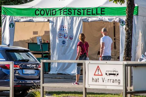 Passanten gehen vor einer Corona-Teststelle vorbei