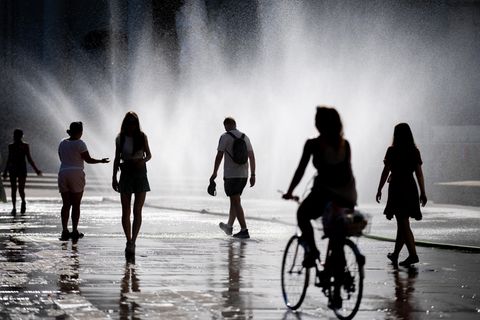 In Wien erfrischen sich Menschen auf dem Karlsplatz